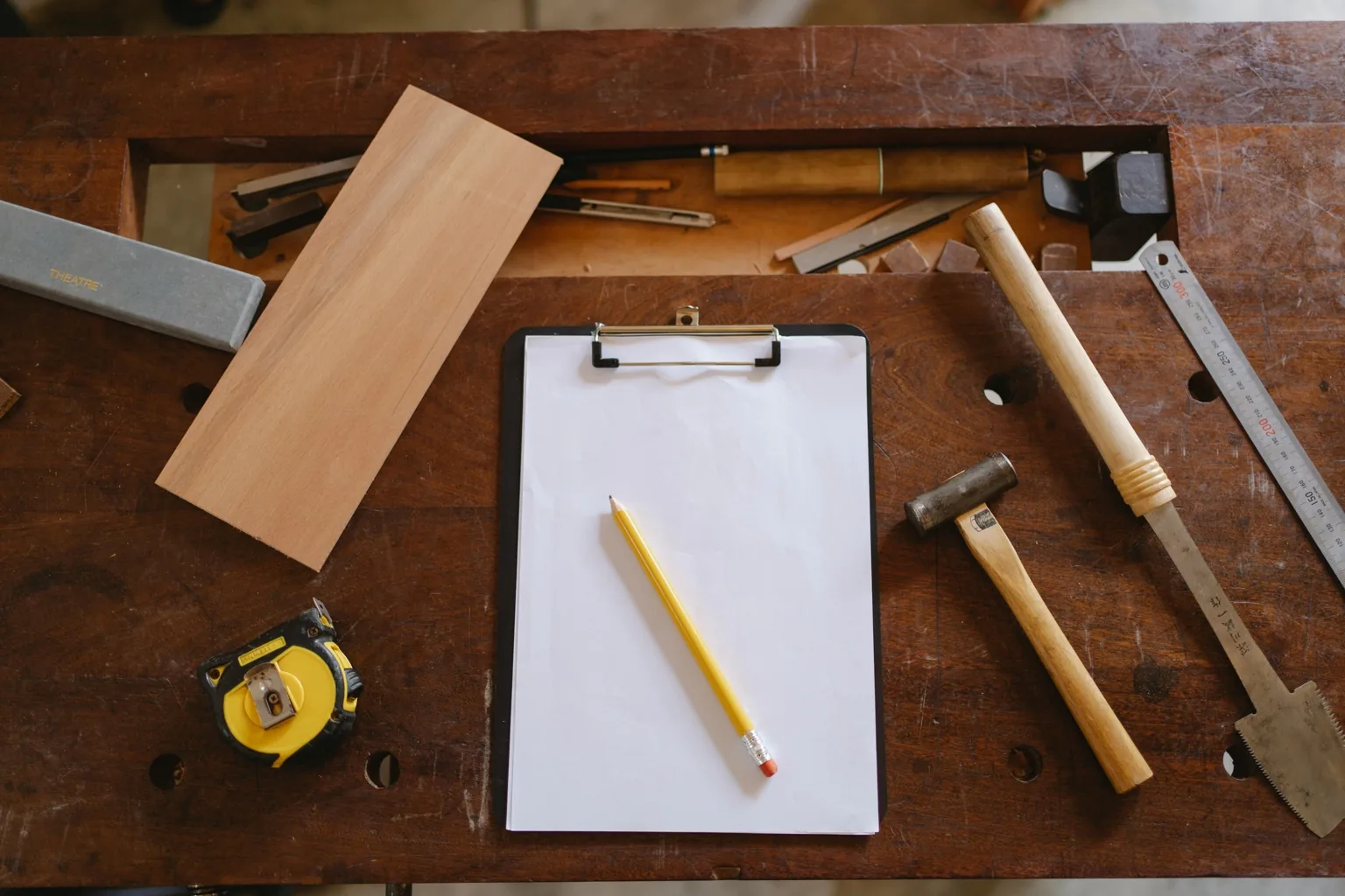 Werkbank met potlood, meetlint en gereedschap